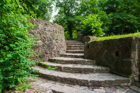 Old stone staircase and wall in a green parkの写真素材