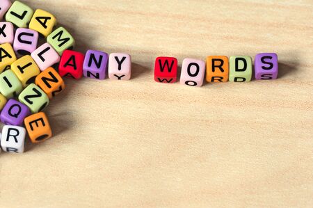 Many colorful blocks with letters which form many words, on light wooden backgroundの写真素材