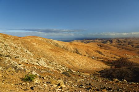 Spectacular coloring and structure of a rural park of Betancuria in Fuerteventura, one of the Canary Islands. The terrain is formed by a line up of hills with rounded summits, which steeply slope down to the bottom of the ravines.の写真素材