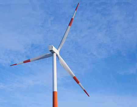 White with red wind turbine on a clear blue skyの写真素材
