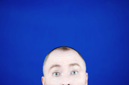 The surprised young mans eyes. Frightened green eyes. The head peeking out from the bottom of the...