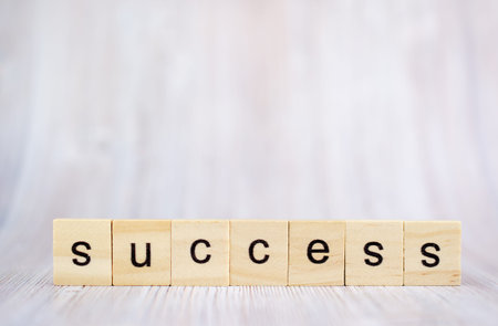 Success word from wooden blocks on desk. Concept of successful in business