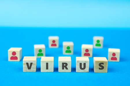 VIRUS inscription on wooden cubes, red and green humans on the background. Diseases, epidemics and pandemics medical conceptの写真素材