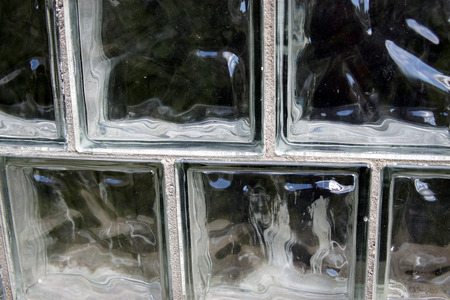 A wall of glass blocks with a dark behind themの写真素材