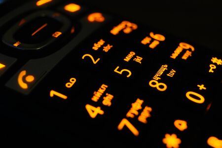 Glowing phone buttons in the dark closeup photoの写真素材