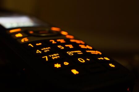 Glowing phone buttons in the dark closeup photoの写真素材