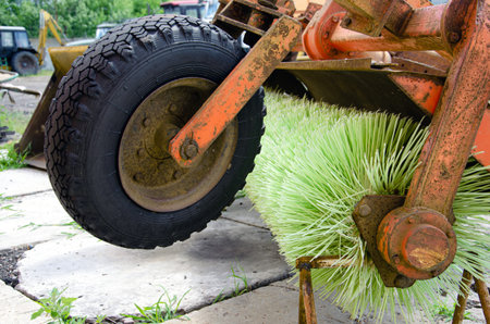 Hinged brush roller for cleaning streets and sidewalks