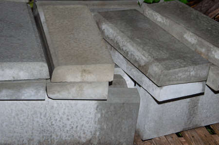 A stack of Gray Concrete road curbs is lying on a sidewalk before the reconstruction of the road. Concrete construction kerbs for a new sidewalkの写真素材
