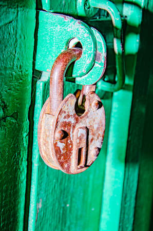 Golden padlock on old green wooden doorの写真素材