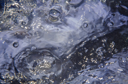Surface of intensive boiling water with bubbles and swirls