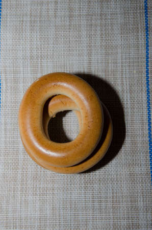 Fresh bread bagel with poppy seed on sackcloth. Russian traditional bakery product.の写真素材