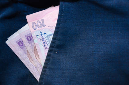 Ukrainian money. Hryvnia banknotes of the national currency in the back pocket of blue pants.の写真素材