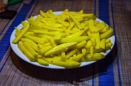 French fries, chips on a white plate. Top view. Cooked in a microwave oven