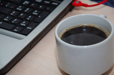 Notepad and coffee cup on wood table. View from aboveの写真素材