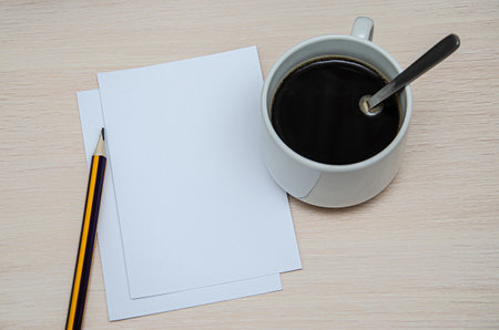 booklet, pencil and coffee cup on wood background. Responsive design mockup.の写真素材