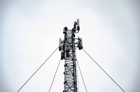 Telecommunication engineer working on high tower,Risk work of high work,Technician working with safety equipment on tower,Sky background.の写真素材