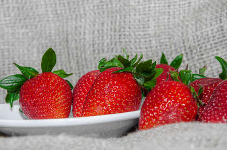 Fresh strawberries in a bowl on a backgroundの写真素材