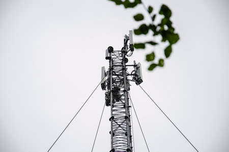 Telecommunication engineer working on high tower, Risk work of high work, Technician working with safety equipment on tower, Sky background. Technician take picture while working on tower.の写真素材