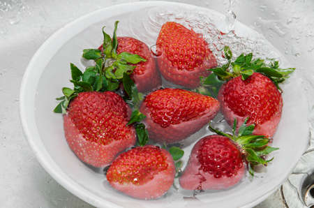 Fresh strawberries in a bowl on a textile backgroundの写真素材
