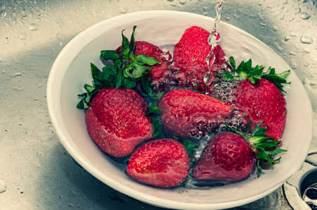 Fresh strawberries in a bowl on a textile backgroundの写真素材