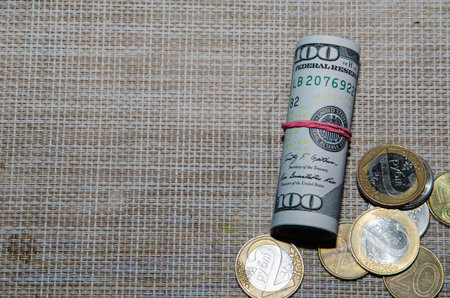 American dollar in the autumn forest, green moss with twisted dollar bills, close up.の写真素材