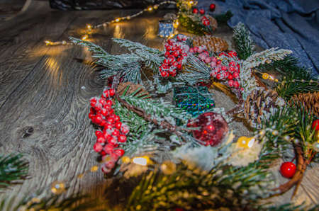 New Years background. On light wooden boards lie spruce branches, New Years decor, a box with a red bow.の写真素材