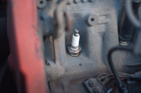 old and new car candles close up lie on a car engine motor