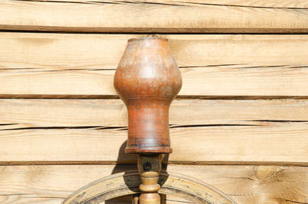 Two terra cotta pots hung on fence at countryside. Antique traditional tableware. Rustic homemade vessel. Ceramic pitcher. Hand manufactured clay pot handcrafted. Ceramic clay vase water pot crockery.の写真素材