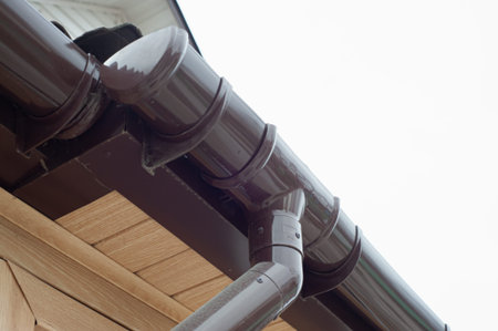 Gutter with downpipe on the roof of a house.
