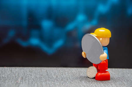 A female hand holds a golden plastic bank card on a blurred tile background. financialの写真素材