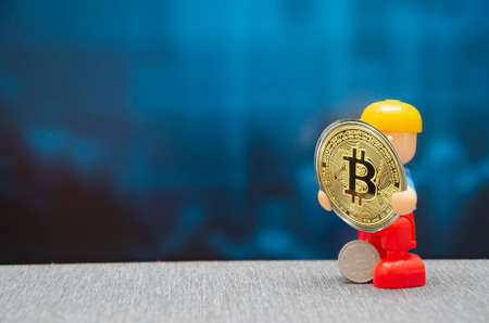 A female hand holds a golden plastic bank card on a blurred tile background. financialの写真素材