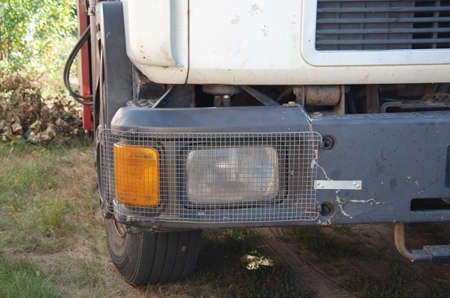 Signal headlamp protected by a metal grating from a heavy truck for industrial purposes frontの写真素材