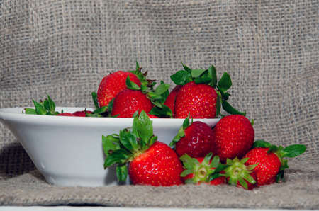 Fresh strawberries in a bowl on a textile backgroundの写真素材