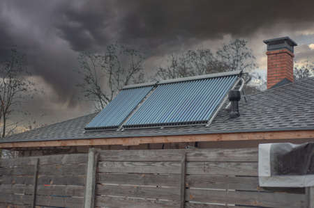 Energy generation sunpower collecting solar panels on a roof of farmhouse roof with opened window energyの写真素材