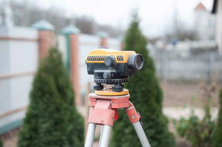 Surveying measuring equipment level transit on tripod at construction buildingの写真素材