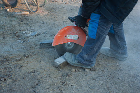 A worker cuts paving slabs with a gas cutterの写真素材