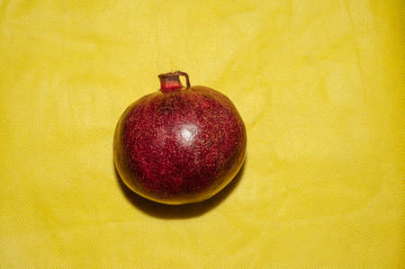 Pomegranate fruit on a yellow background, food redの写真素材