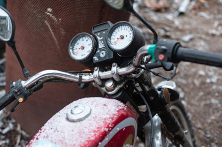 Detail of the steering wheel of a vintage motorcycle on a pavement and a mirror, which reflects a...