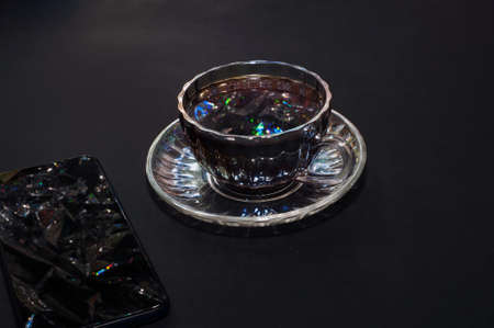 Top view of a cup of coffee, isolate on black and a smartphoneの写真素材
