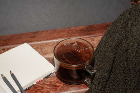Top view of a cup of coffee and a notebook with pencils and an eraser, isolate on blackの写真素材