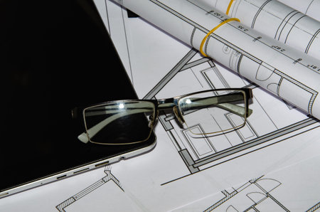 architects work table with technical drawings and tablet computer.