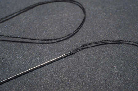 Needle and thread for needlework black backgroundの写真素材
