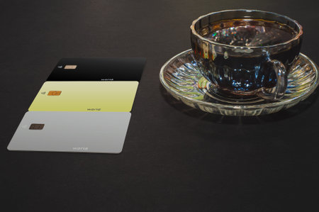 Top view of a cup of coffee and black, gold, silver, credit card, isolate on black