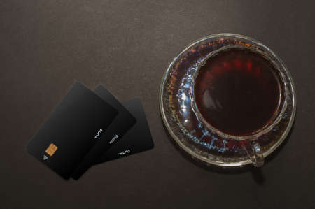 Top view of a cup of coffee and black credit card, isolate on blackの写真素材