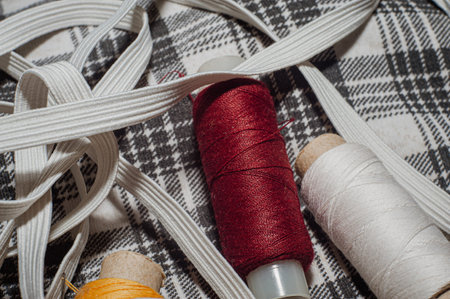 Spools with threads on a checkered woven background.