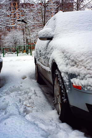 Fresh snow on the car. The first snowfall and the end of autumn. Change of weather from autumn to winter.の写真素材