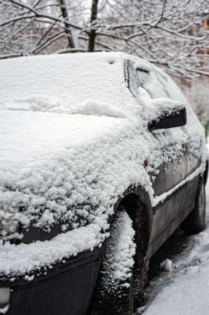 Fresh snow on the car. The first snowfall and the end of autumn. Change of weather from autumn to winter.の写真素材