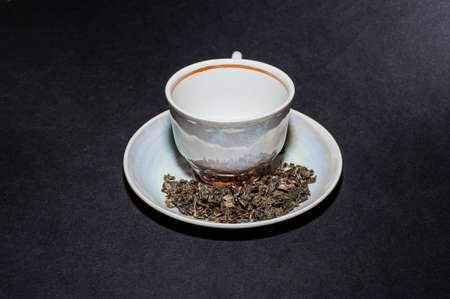 Dry tea with green leaves in spoons, on black backgroundの写真素材