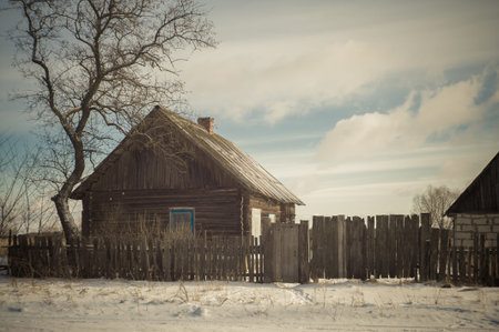 Old wooden abandoned house next to a road in northern Russia.の写真素材