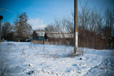 Old wooden abandoned house next to a road in northern Russia.の写真素材
